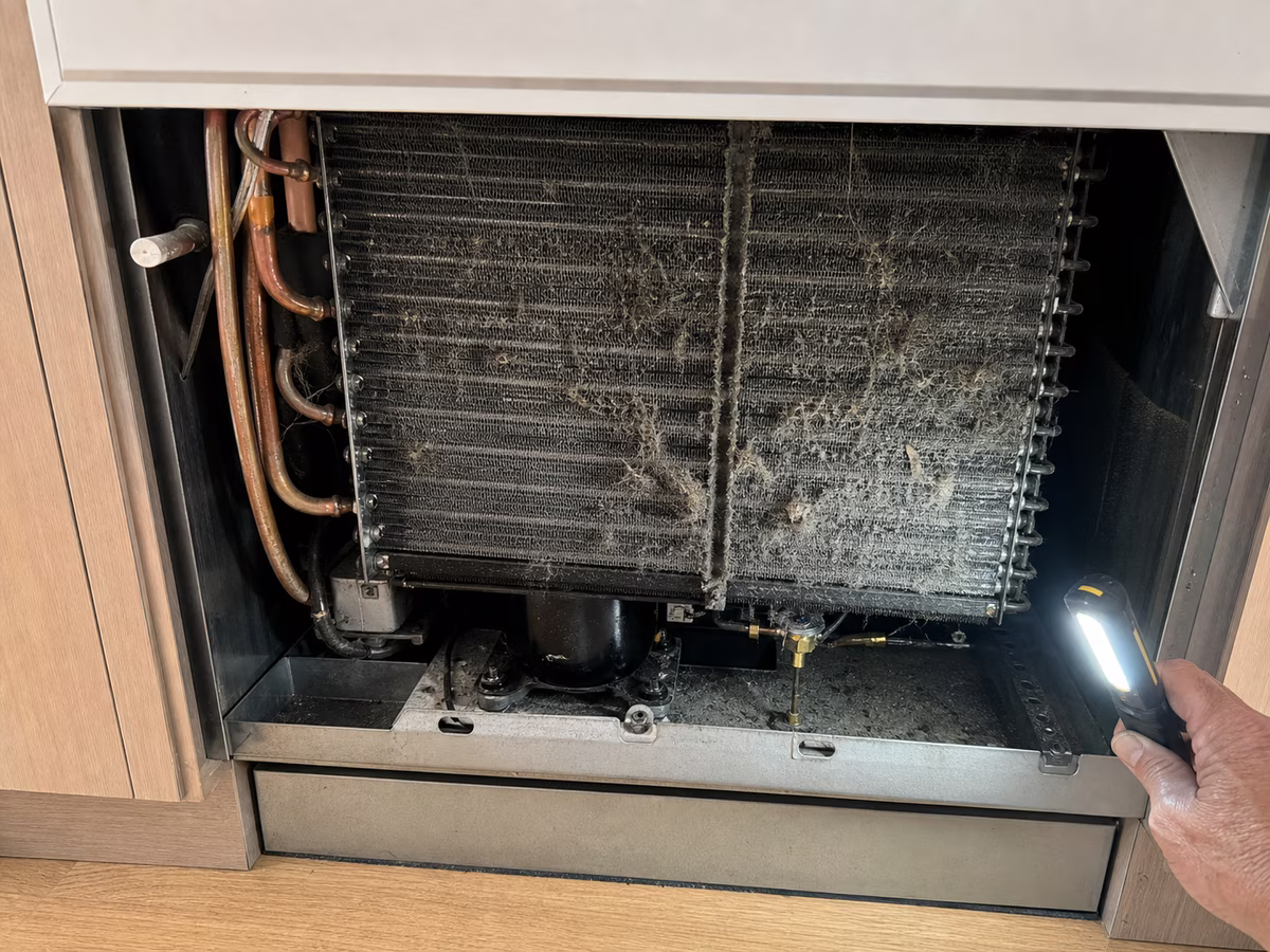 Sub-Zero condenser coil packed with dust and pet hair before cleaning